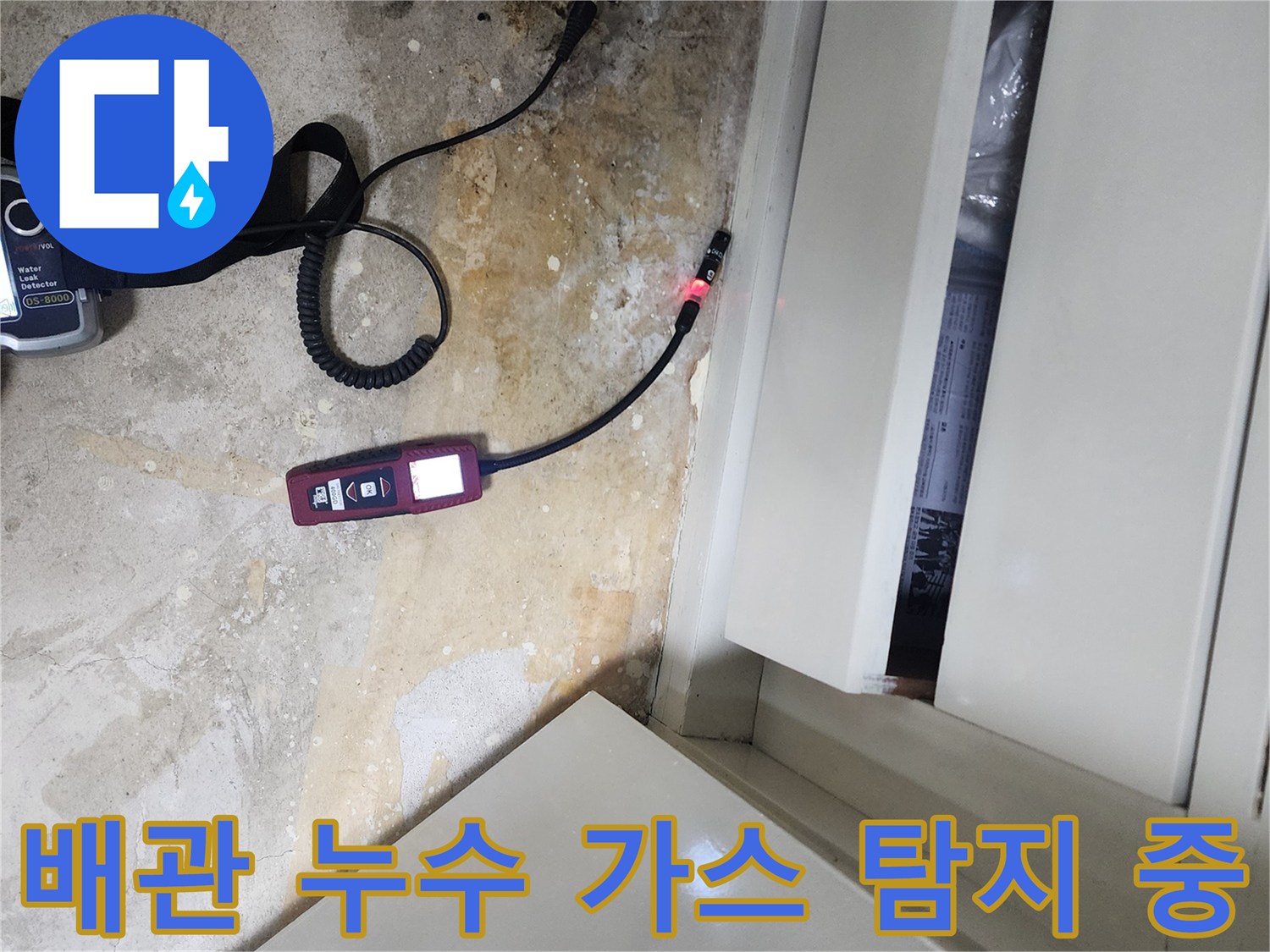 싱크대 하부장 아래-누수 지점을 찾기 위해 가스식 탐지기를 운용하는 장면입니다.