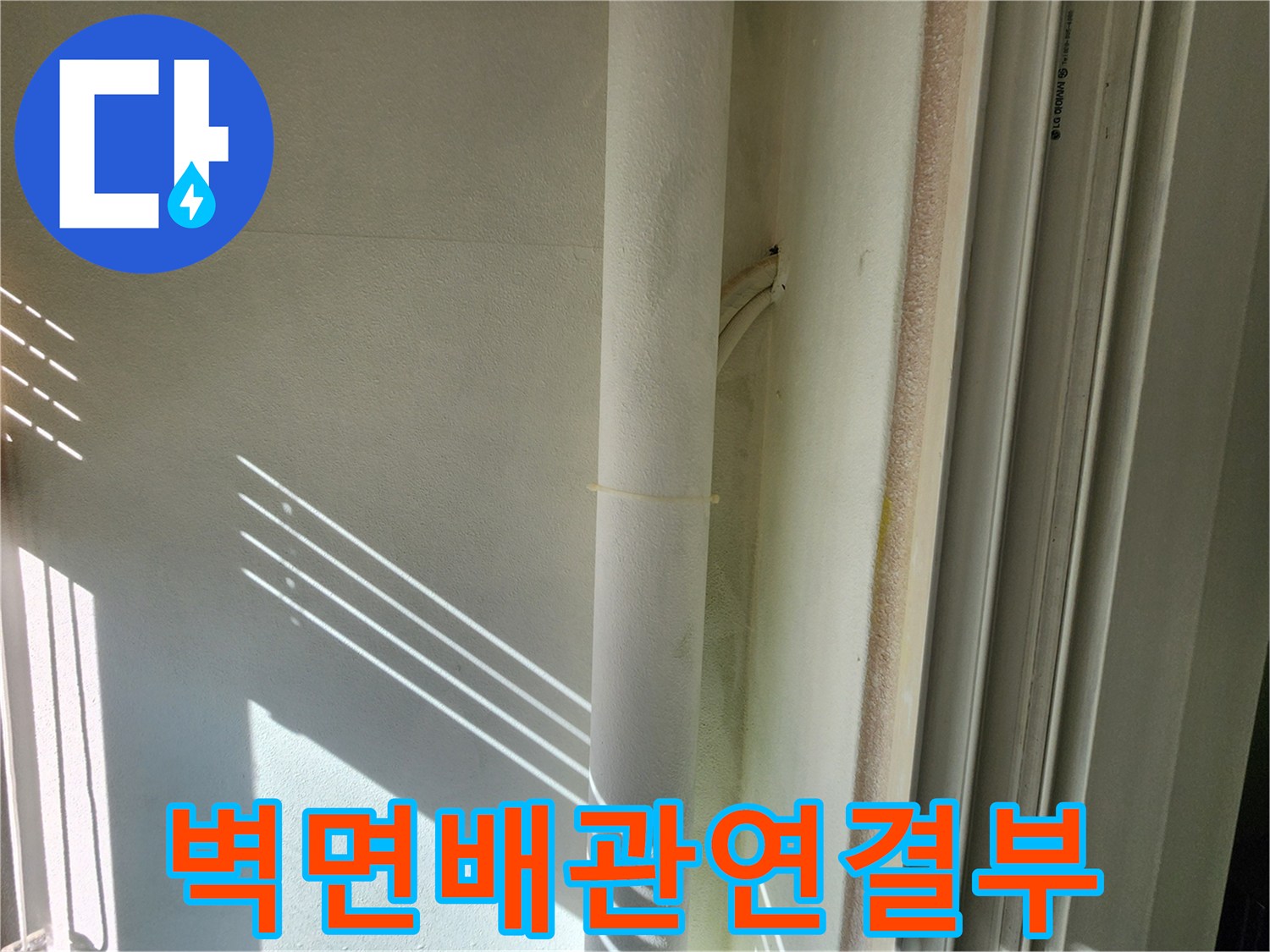 하얀색 배관과 하얀색 벽면이 만나는 지점의 근접 사진입니다.