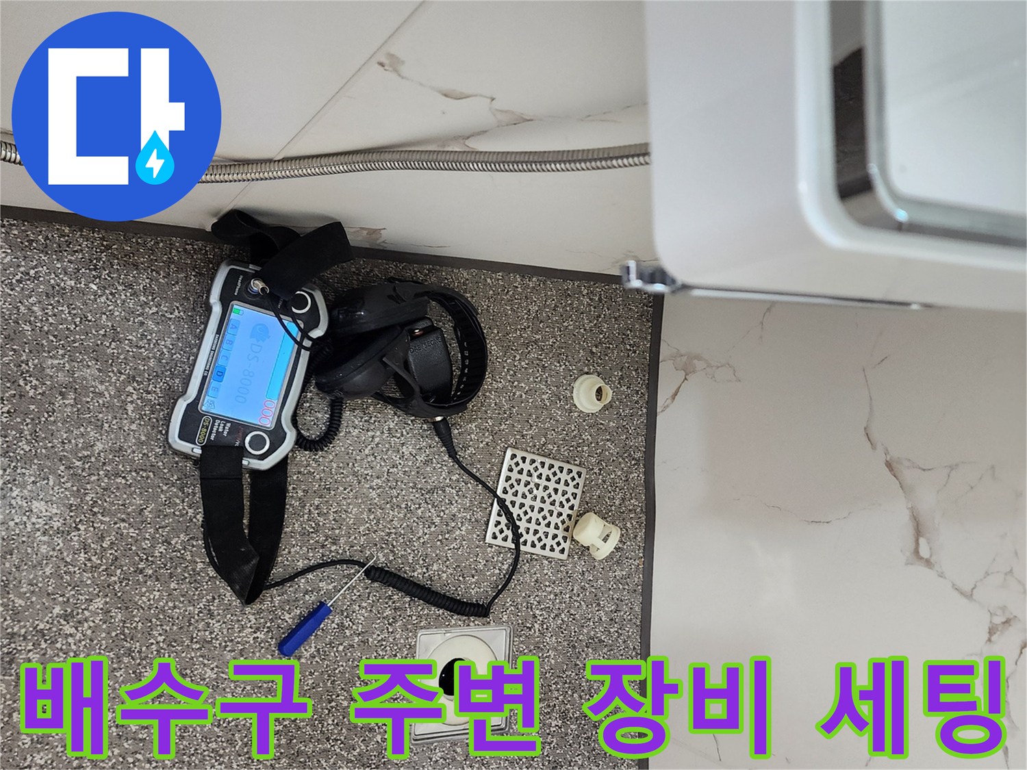 욕실 배수구와 함께 놓여 있는 누수 탐지용 전문 기기