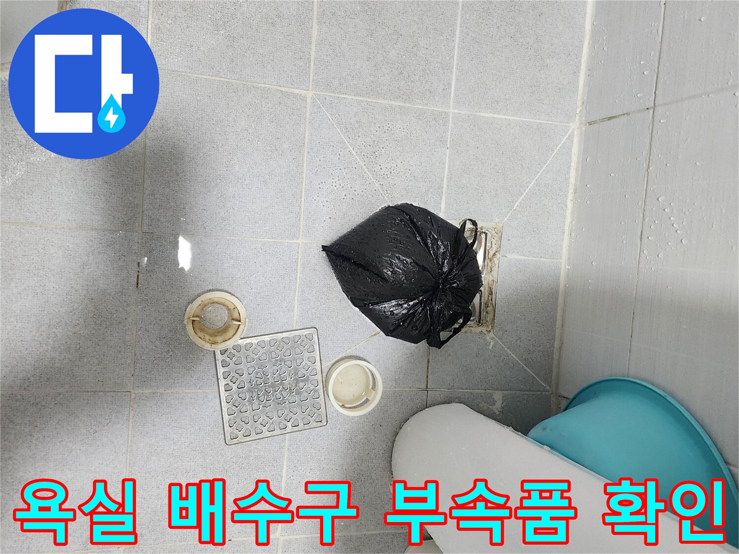 화장실 바닥에 놓인 배수구 덮개와 세척용 도구들 - 누수 원인 파악을 위한 준비 단계입니다.