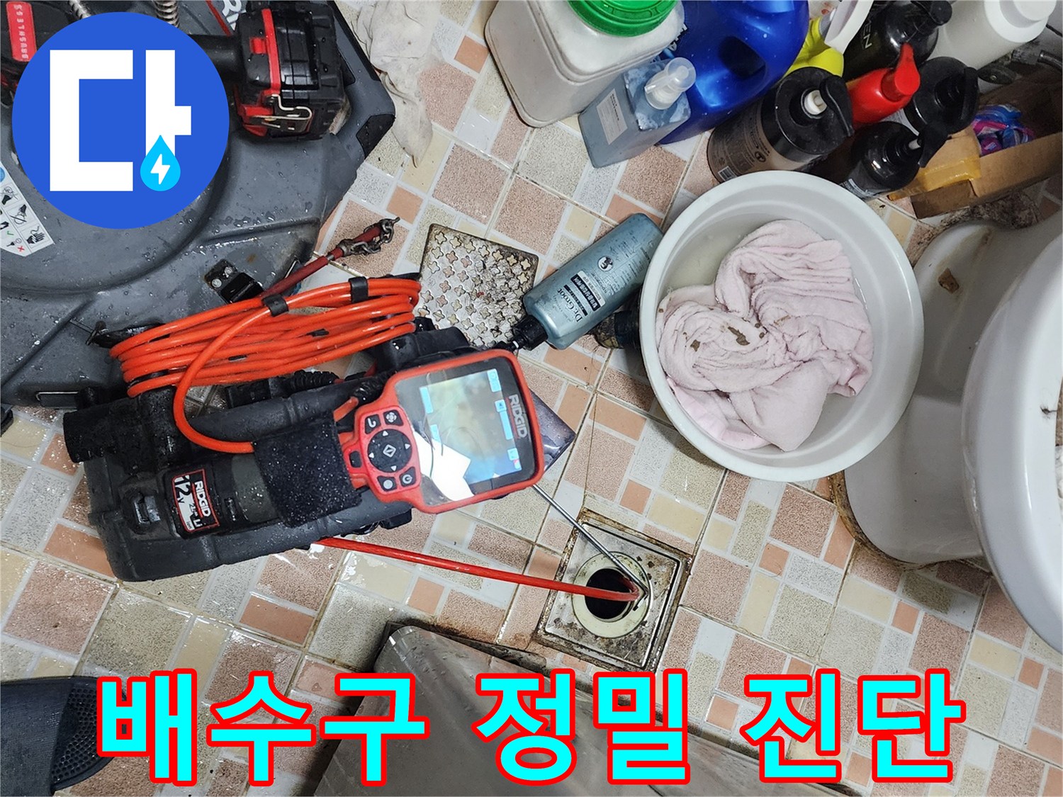 욕실 배수구 주변에 놓인 리지드 전문 탐지 장비와 점검 도구들