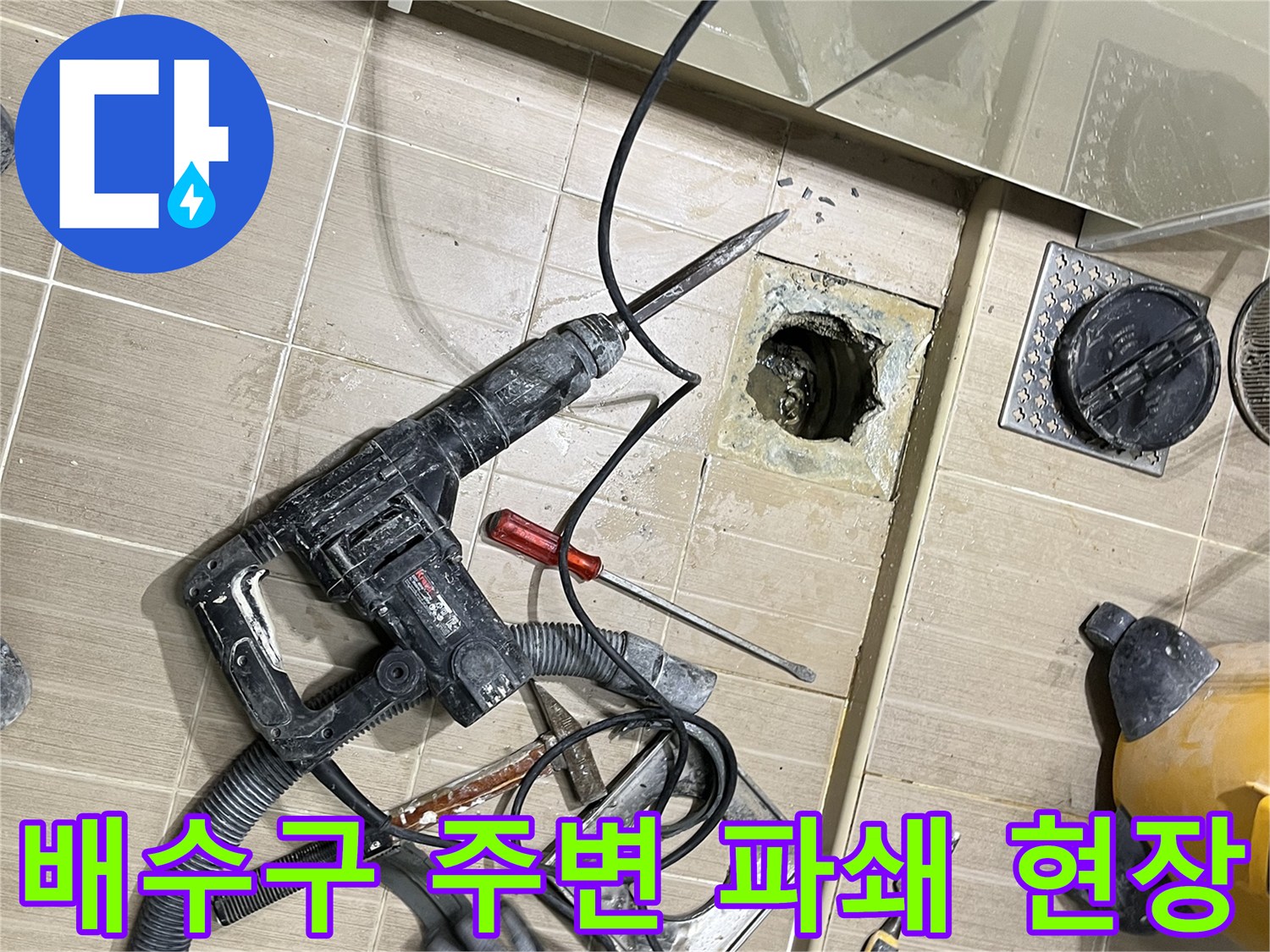 누수 지점을 찾기 위해 배수구 근처 타일을 깨낸 굴착 작업 사진