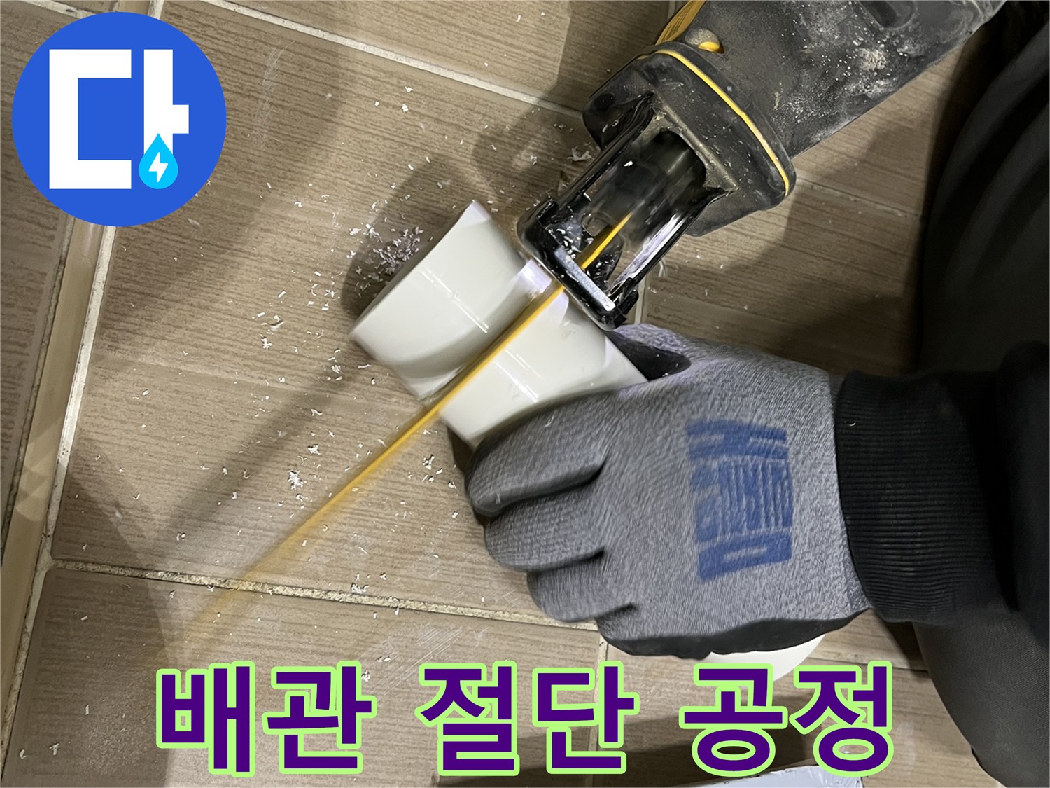 하얀색 배수 파이프를 자르는 전동 기계와 작업자의 장갑 낀 손