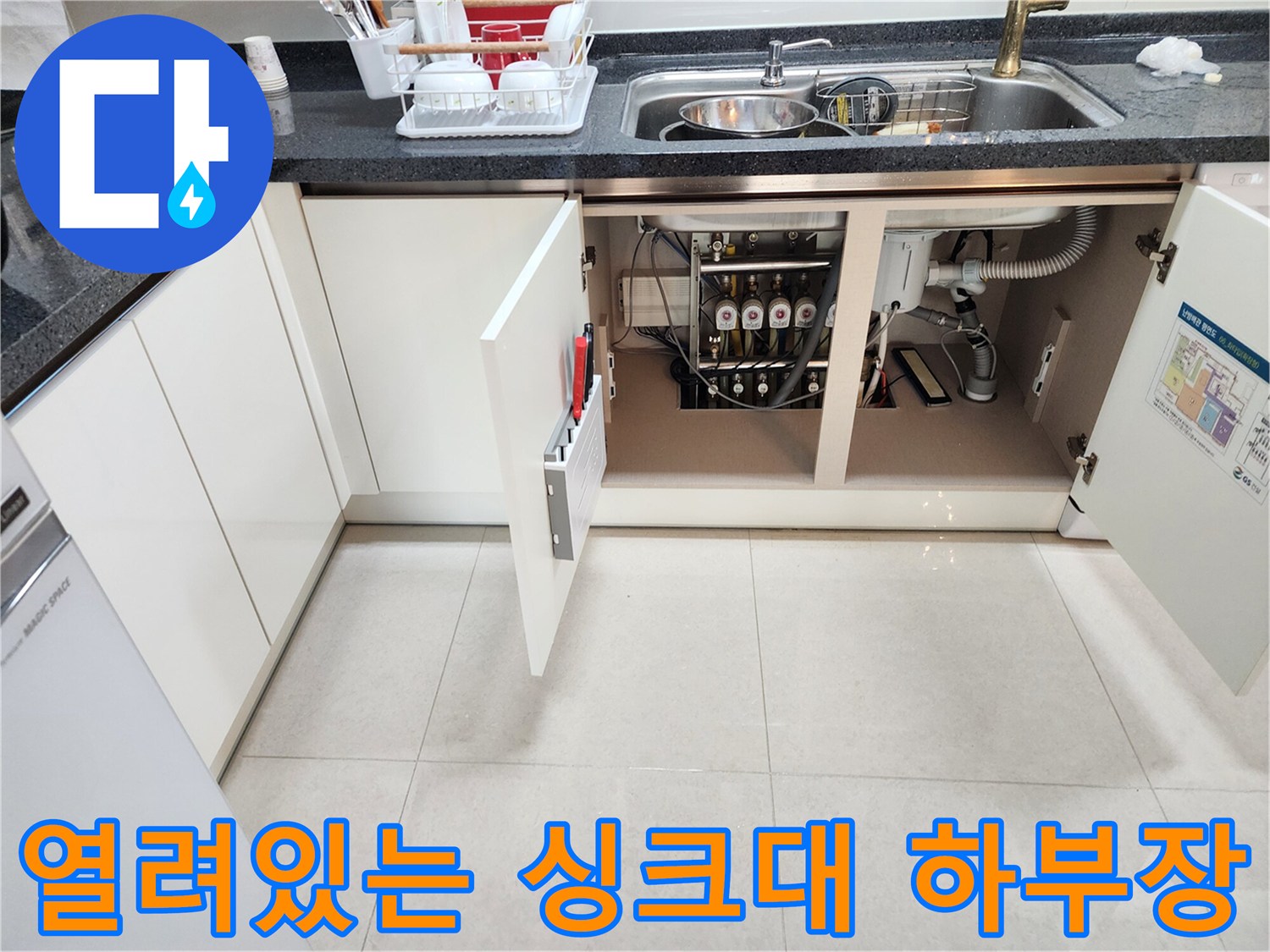 싱크대 밑 하부장 내부의 복잡한 배수 시스템 구조