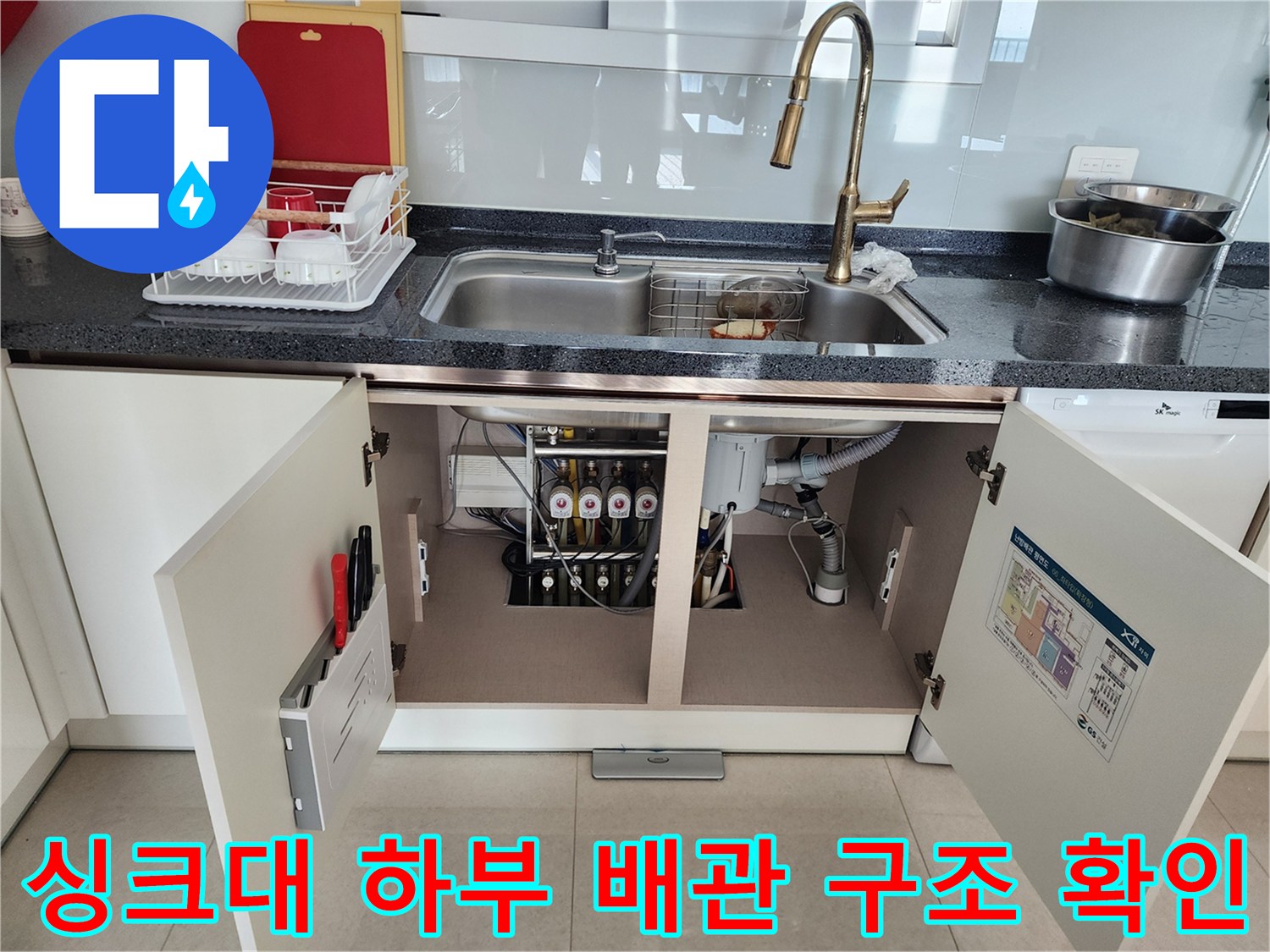 열려있는-싱크대-하부장-내부의-복잡한-배관-시설물
