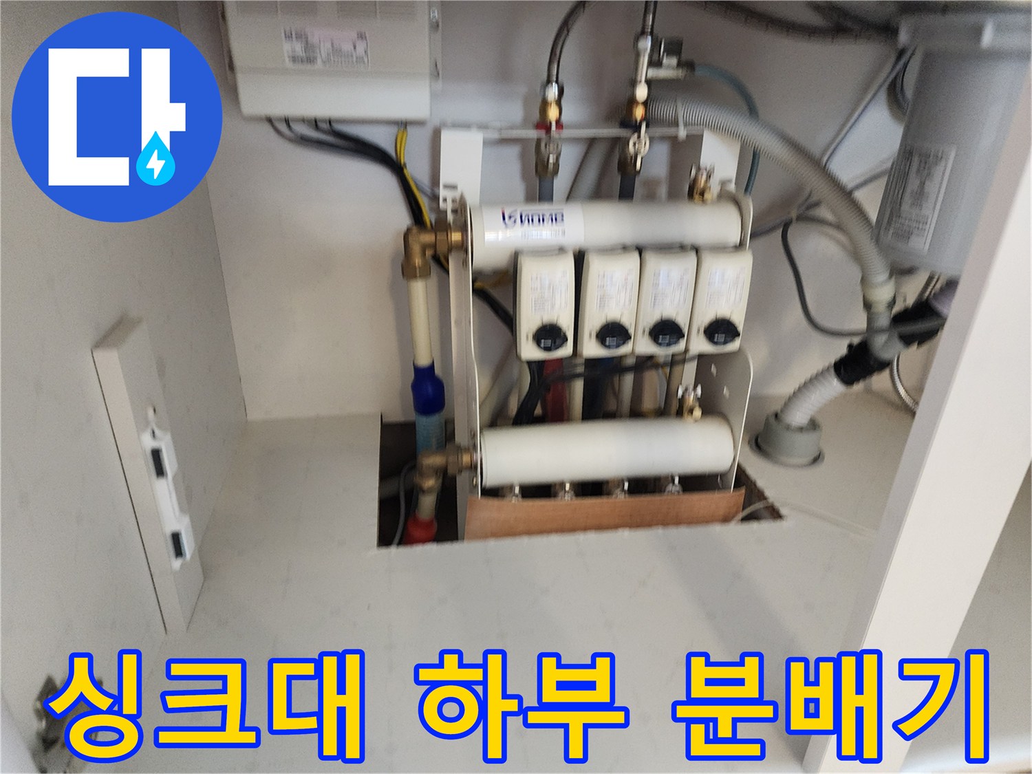 싱크대 아래쪽에 설치된 급수용 분배기와 배관 연결 부위 상세 사진입니다.