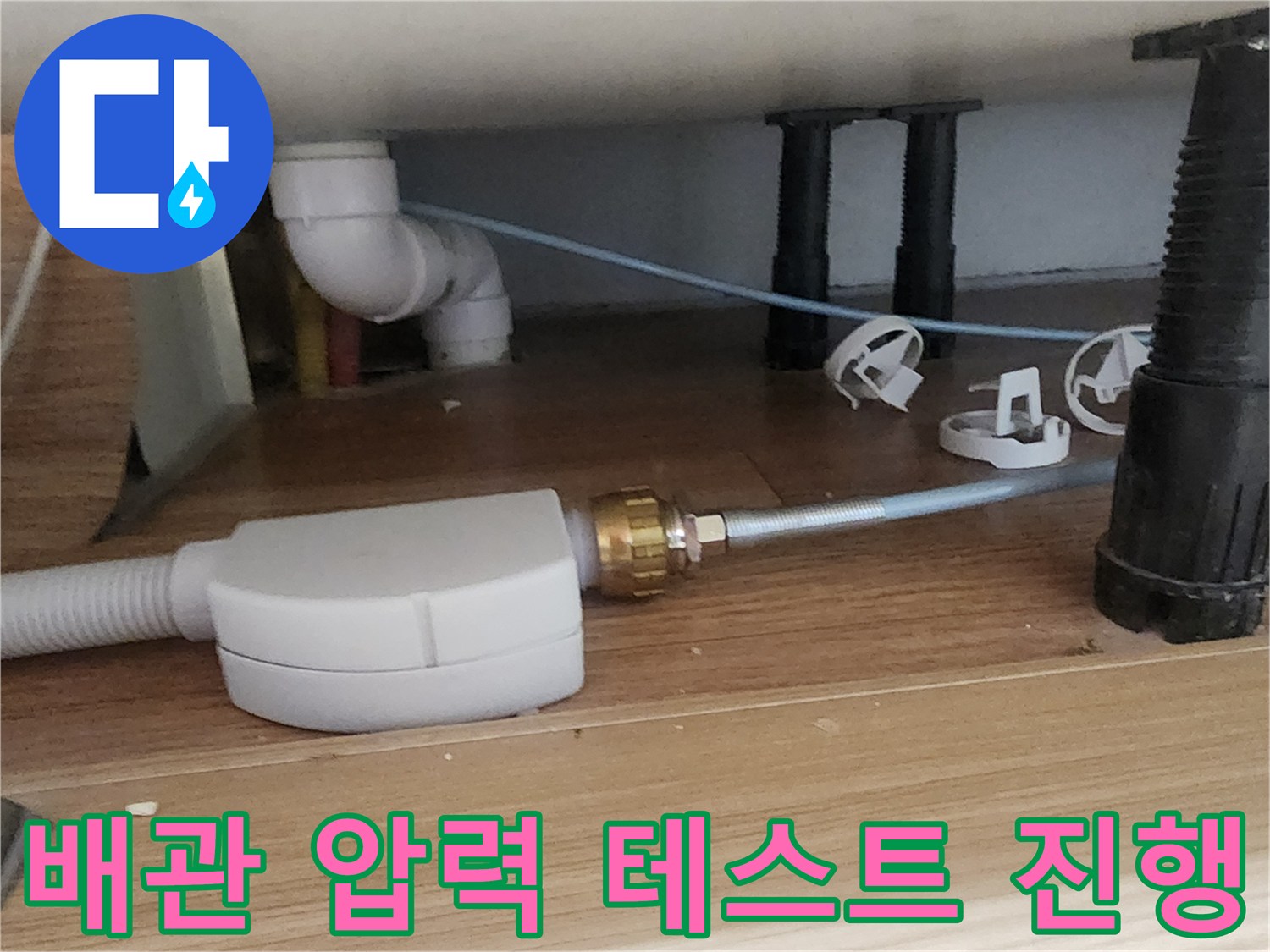 싱크대 하부 배관에 연결된 공압 테스트 장비와 부속품 상세 이미지
