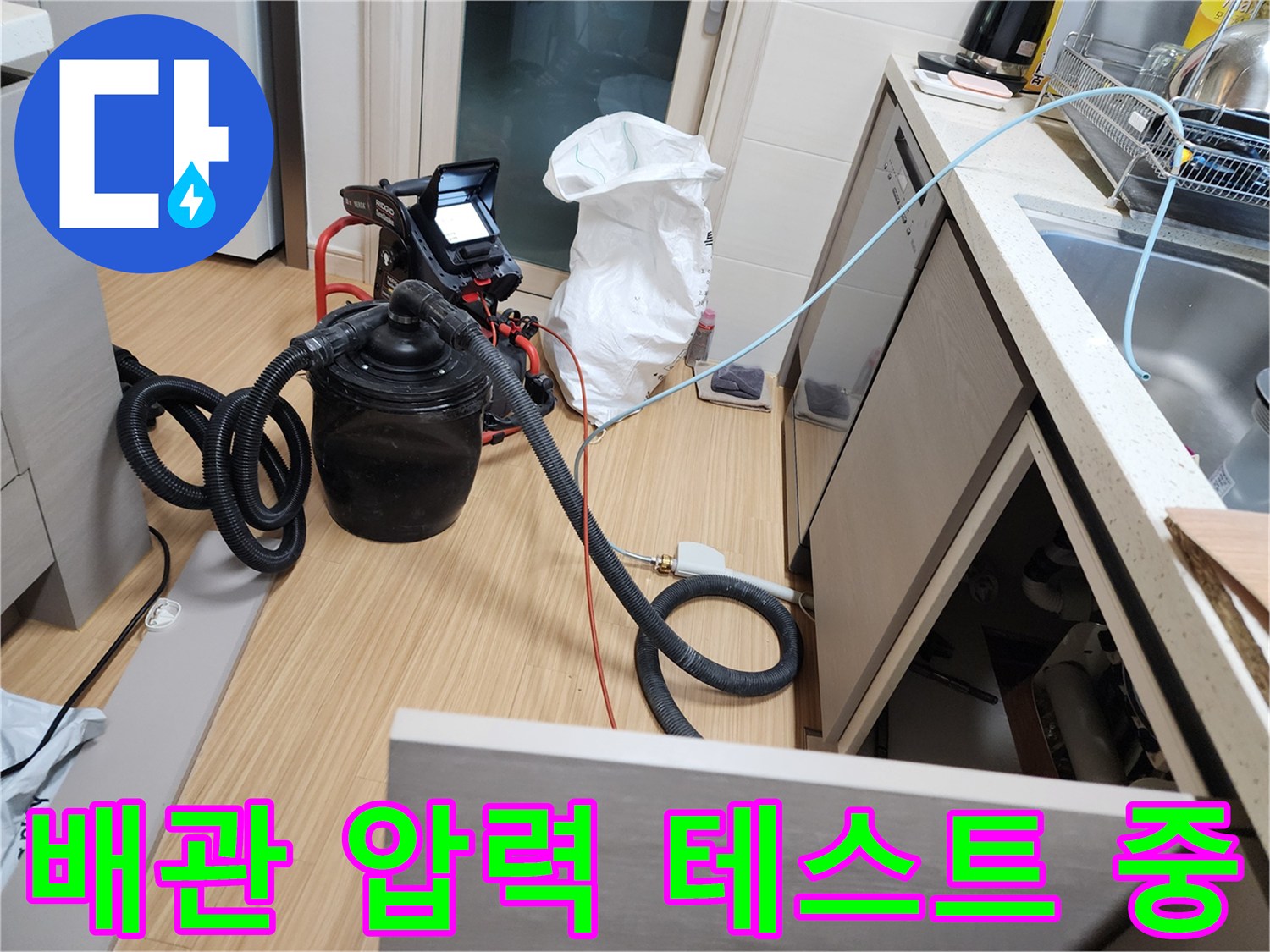 싱크대 하부 배관의 기밀성을 확인하기 위해 공압 테스트기를 연결한 모습입니다.