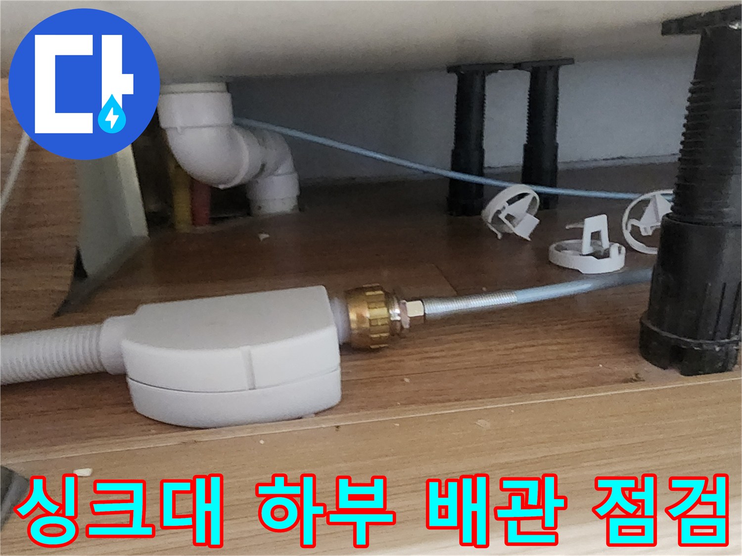 주방 싱크대 하단 배관 연결 부위와 압력 측정기 설치 상태
