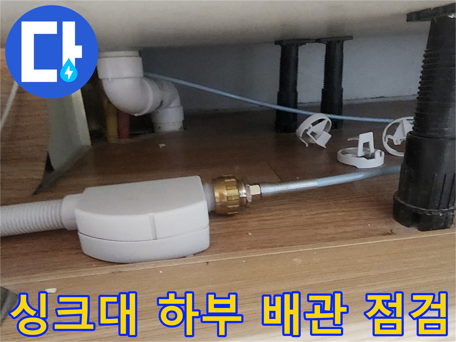 주방 싱크대 하부장 내부의 배관과 압력 테스트 장비 연결 상태