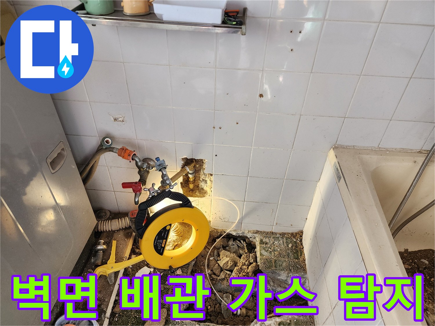 욕실 벽면 배관 부속에 연결된 가스 탐지 호스와 장비 모습