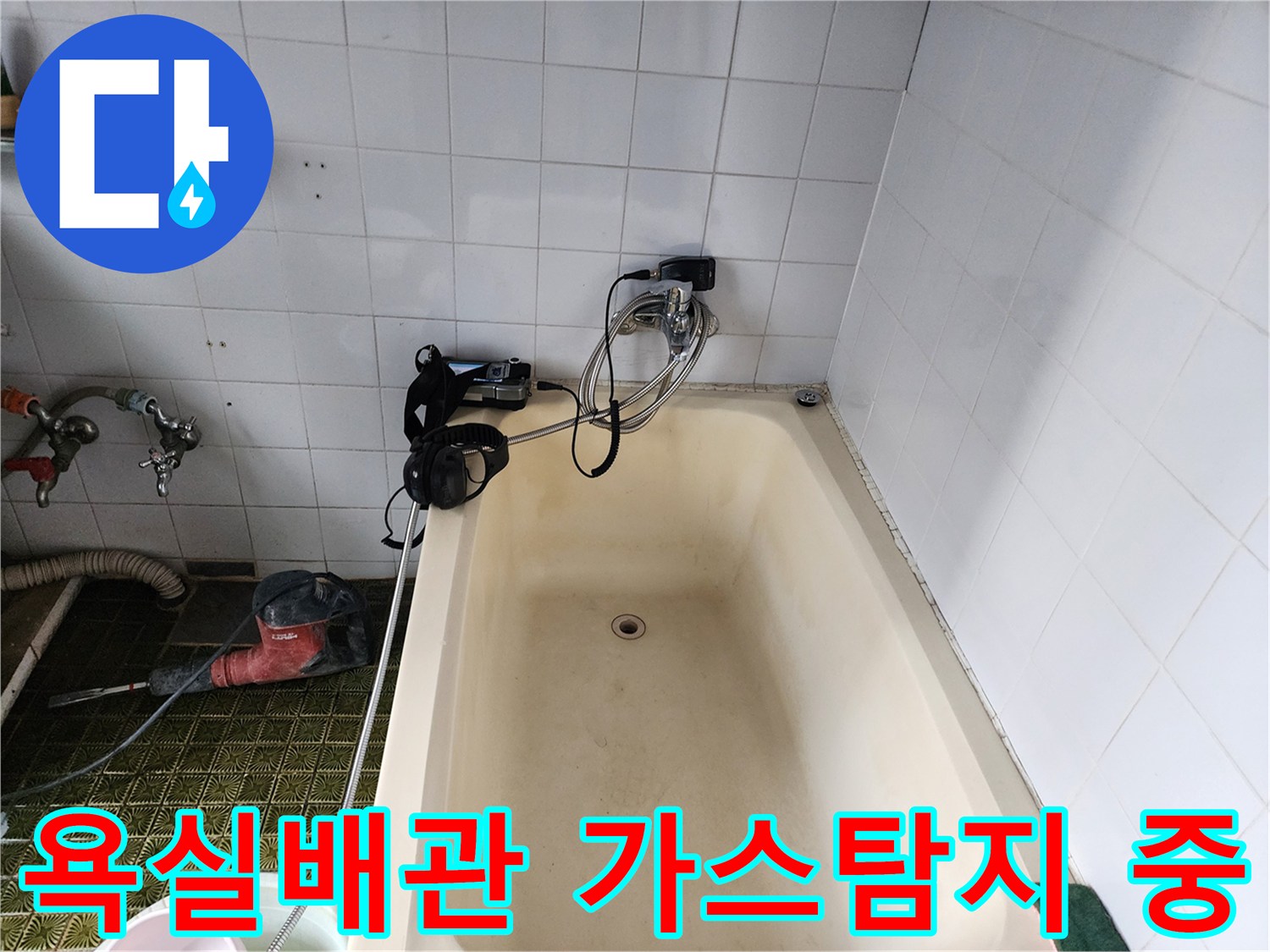 욕실 타일 벽면에 연결된 수도 배관에 가스를 주입하여 누출 부위를 찾는 과정입니다.