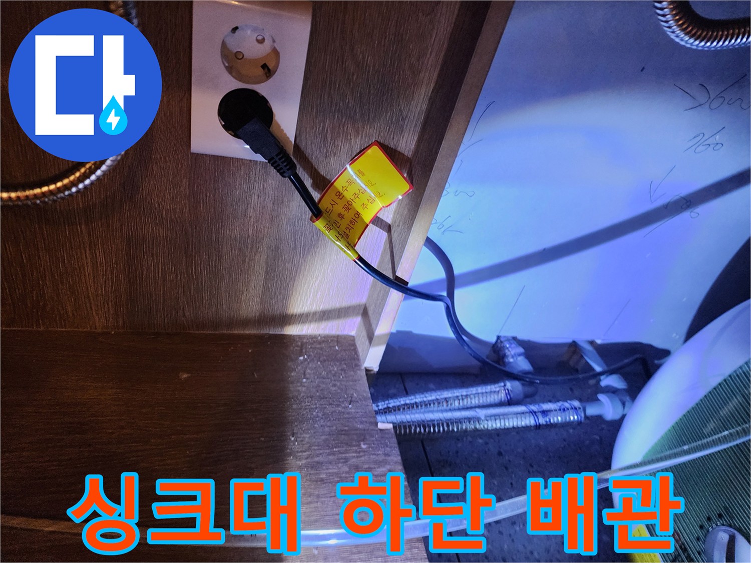전기 온수기와 연결된 금속 호스 및 전원 콘센트 모습