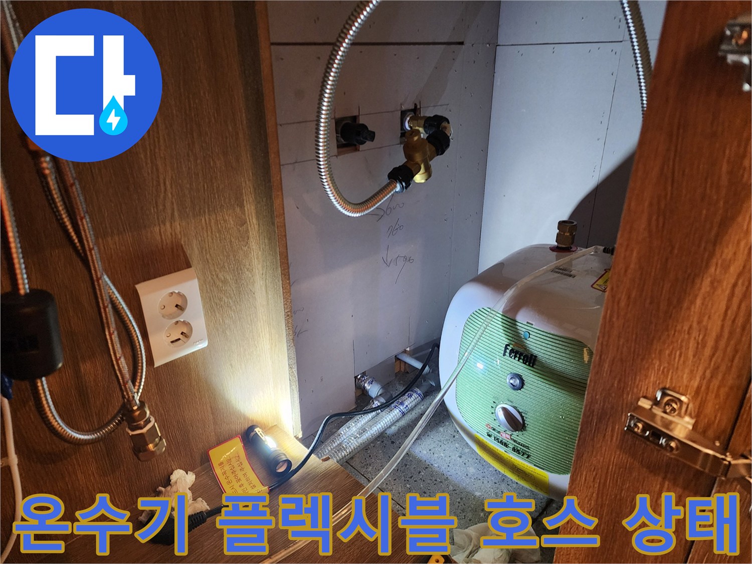 전기 온수기와 연결된 은색 금속 호스의 연결 부위 상세 사진