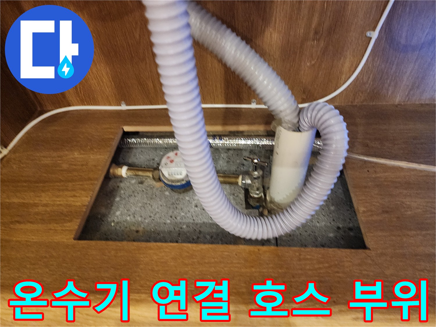 전기 온수기와 연결된 회색 주름관 및 배관 부속품