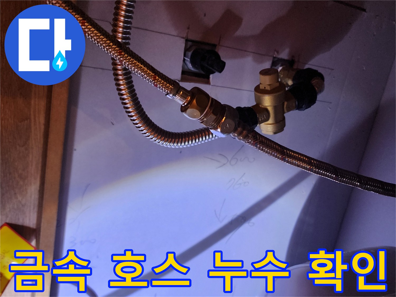 주방 하부장 내 설치된 온수기 배관의 접합 부위 점검 사진