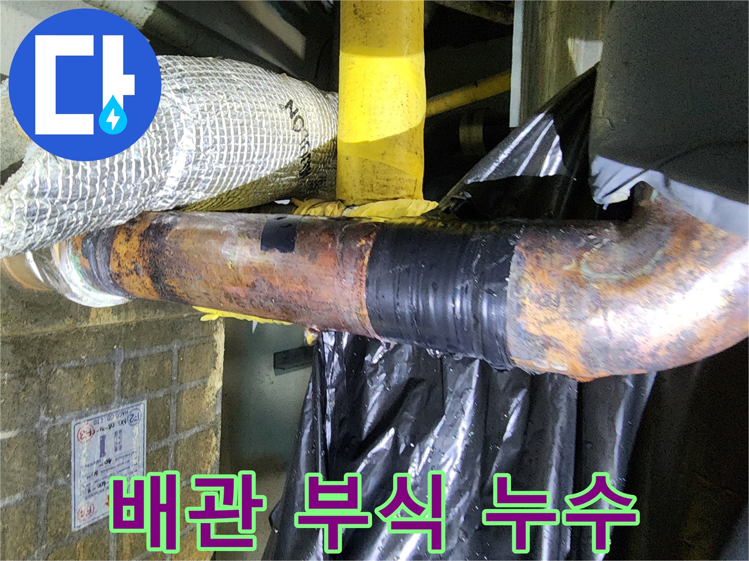 녹슬고-테이프로-감긴-배관에서-물이-새는-긴급-누수-현장-사진입니다.