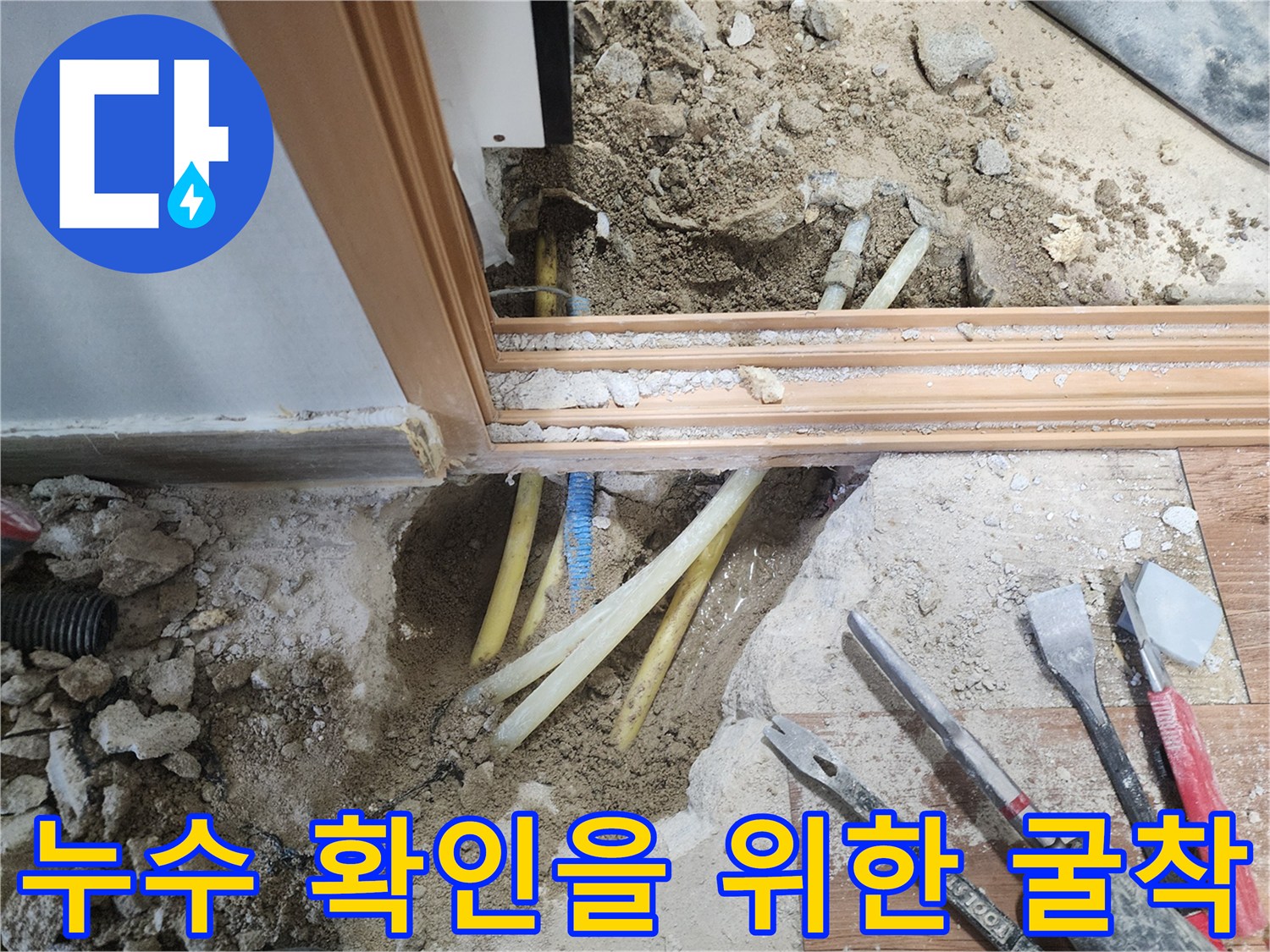 바닥재 하부에 노출된 파손 의심 배관과 공구들