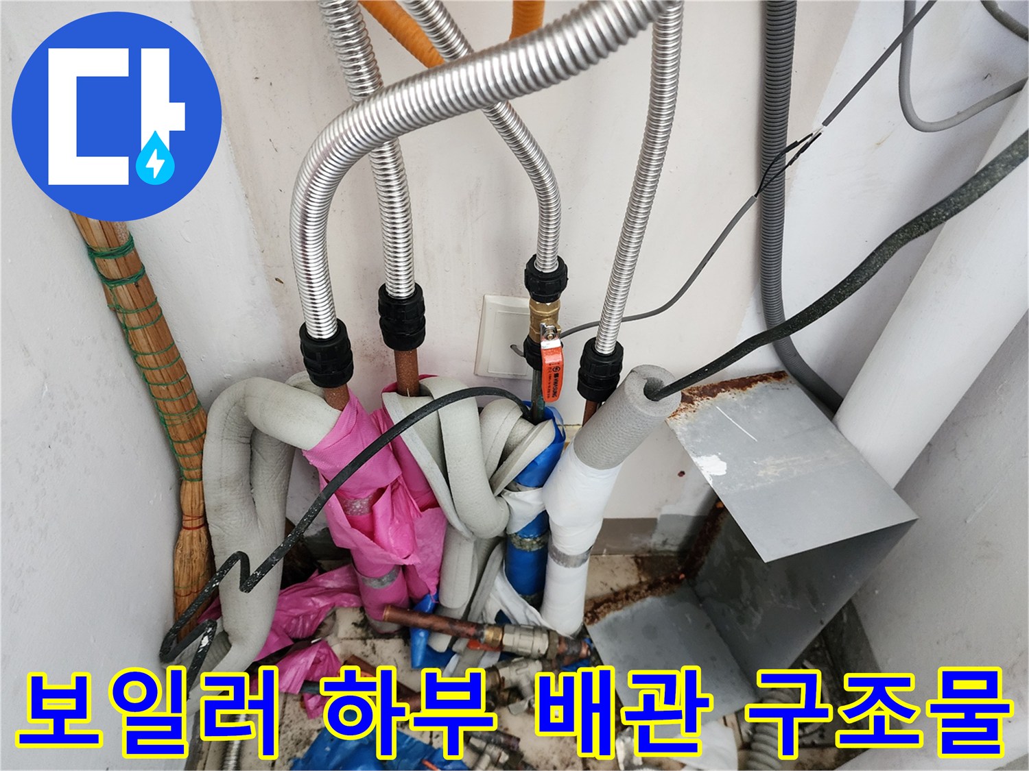보일러 아래쪽의 금속 주름관과 밸브가 포함된 배관 설비
