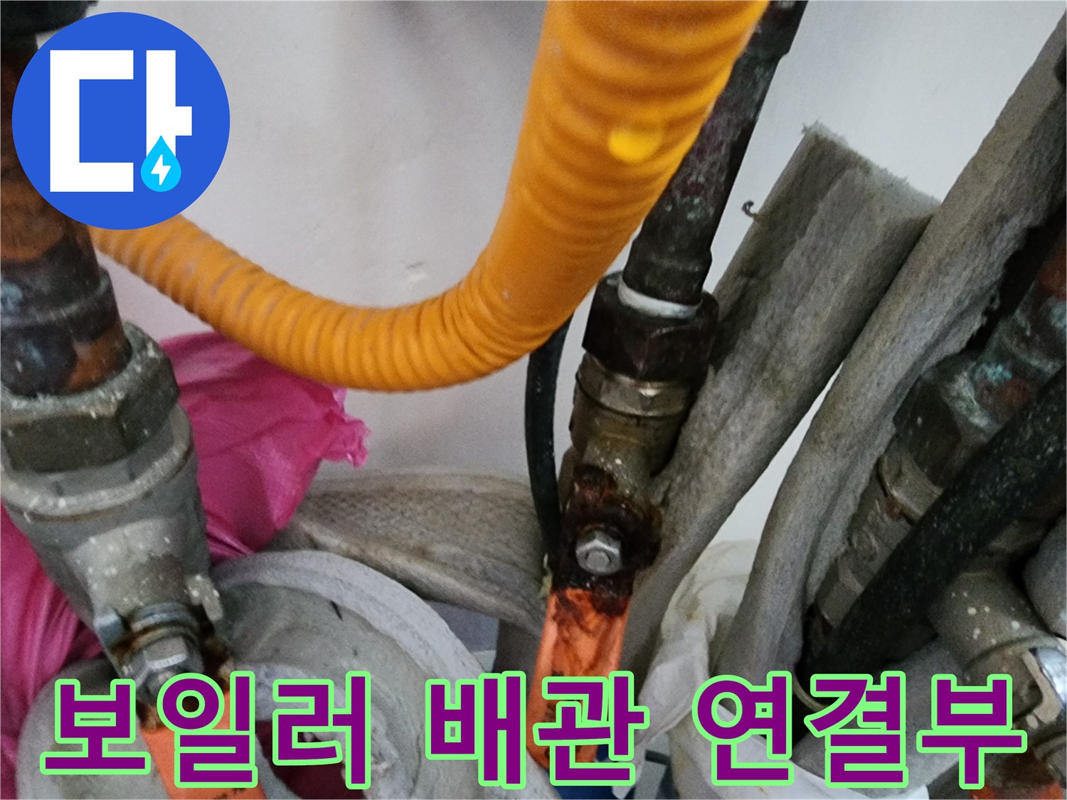 보일러 하부의 복잡한 배관 연결 부위와 노란색 보온재 상태를 보여주는 사진입니다.
