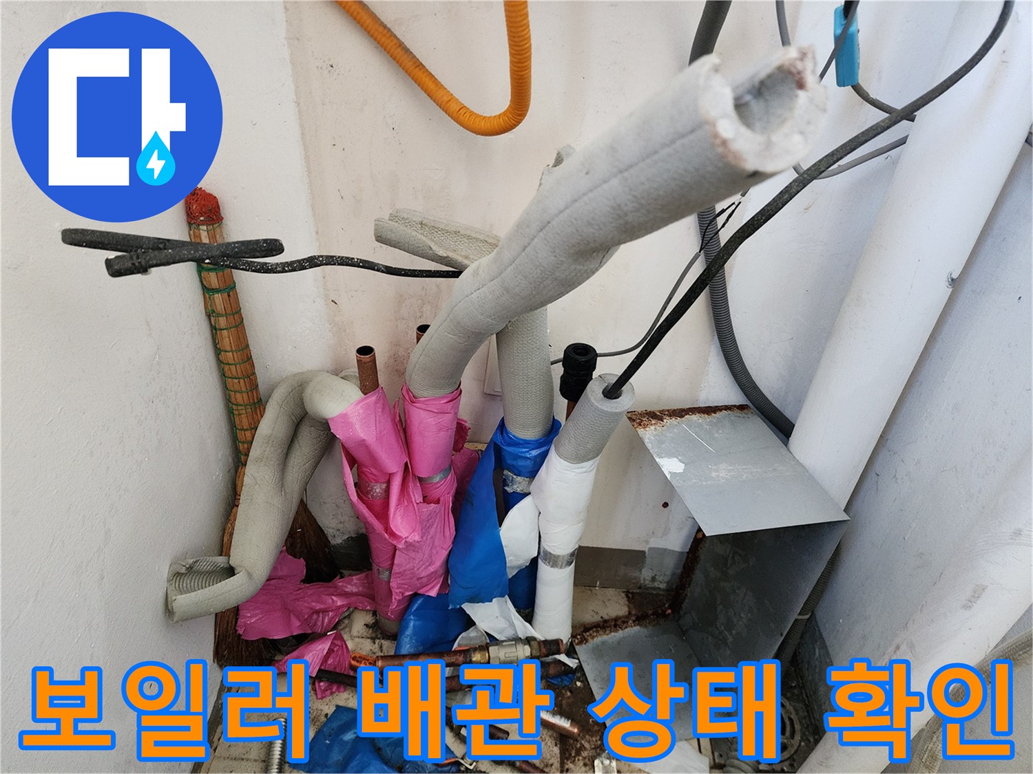 보일러실 하부의 복잡한 배관 연결 부위와 보온재 상태를 점검하는 모습