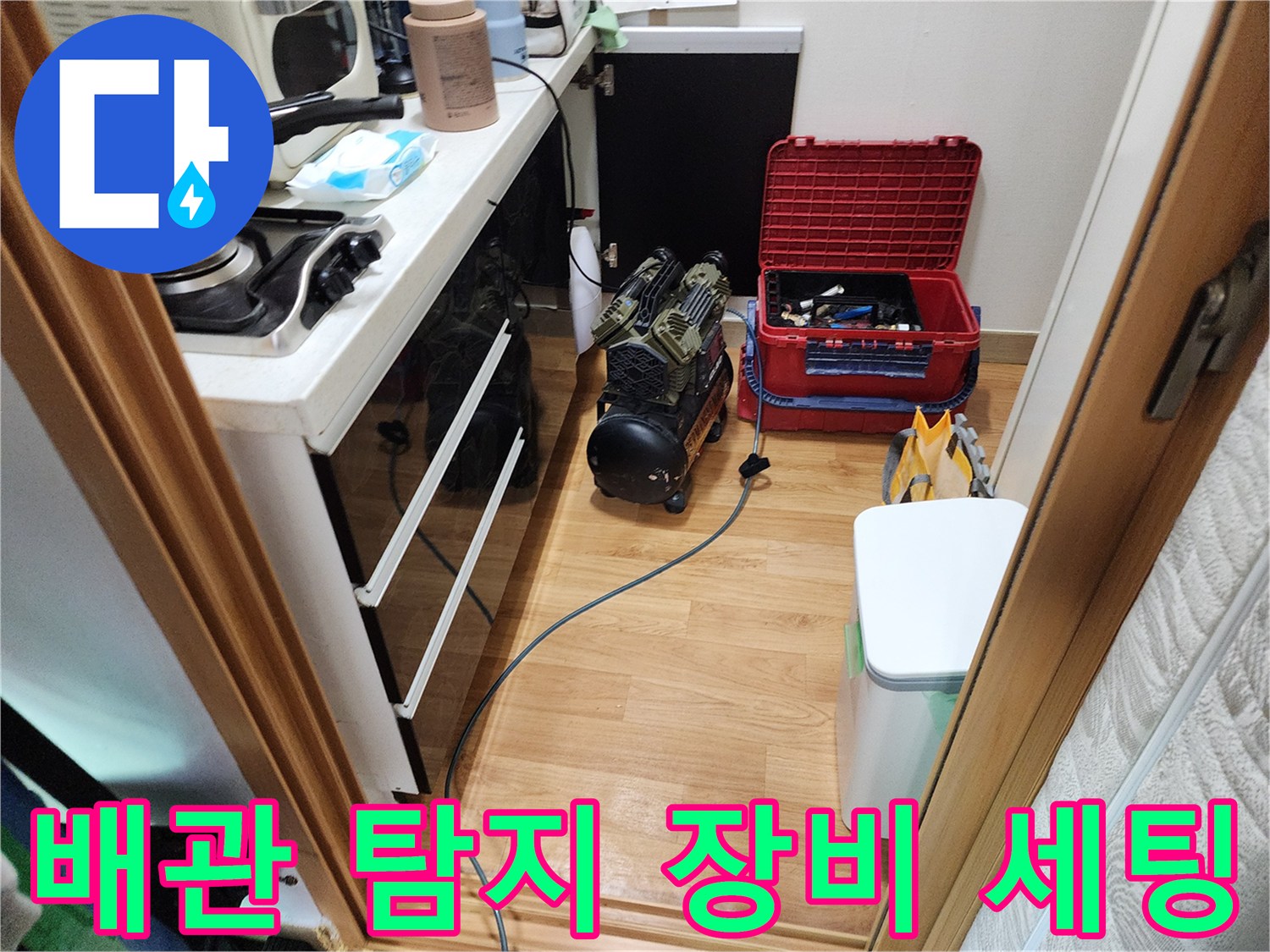 싱크대 아래 공간에 놓인 가스식 탐지기와 공구함
