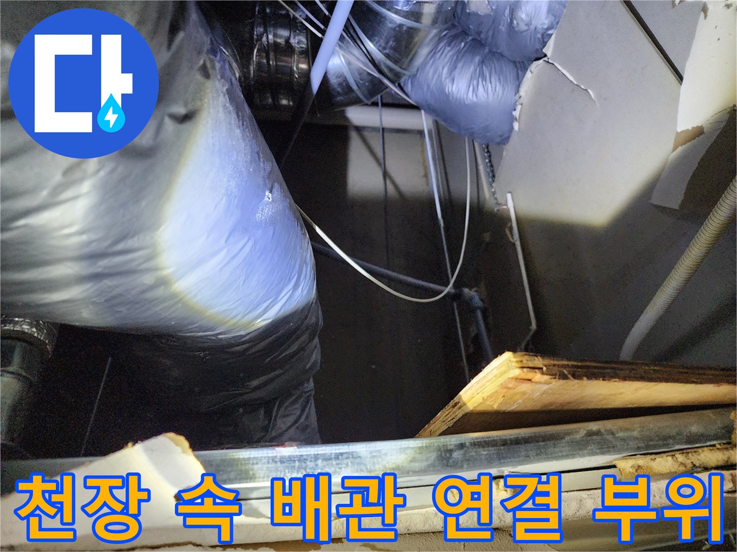 복잡하게 얽힌 천장 내부의 배관과 보양 비닐을 보여줍니다.