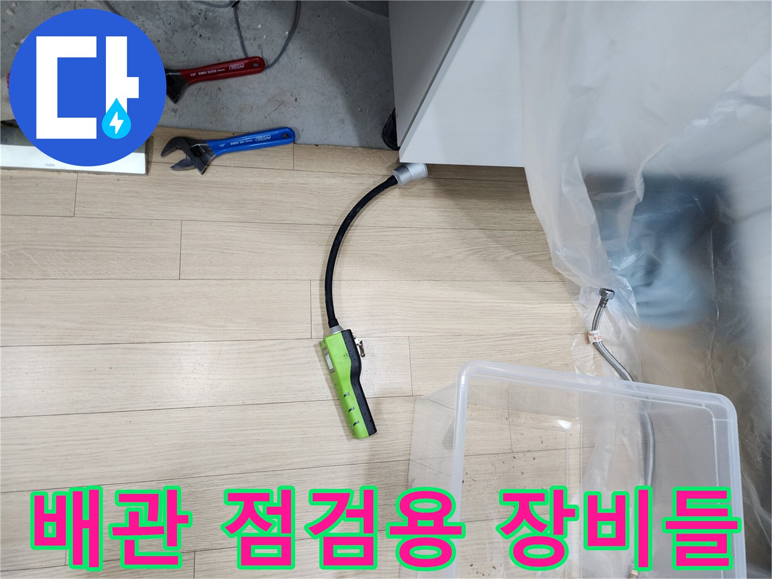 싱크대 하부 보양 작업과 함께 놓여 있는 가스 탐지기 및 공구류