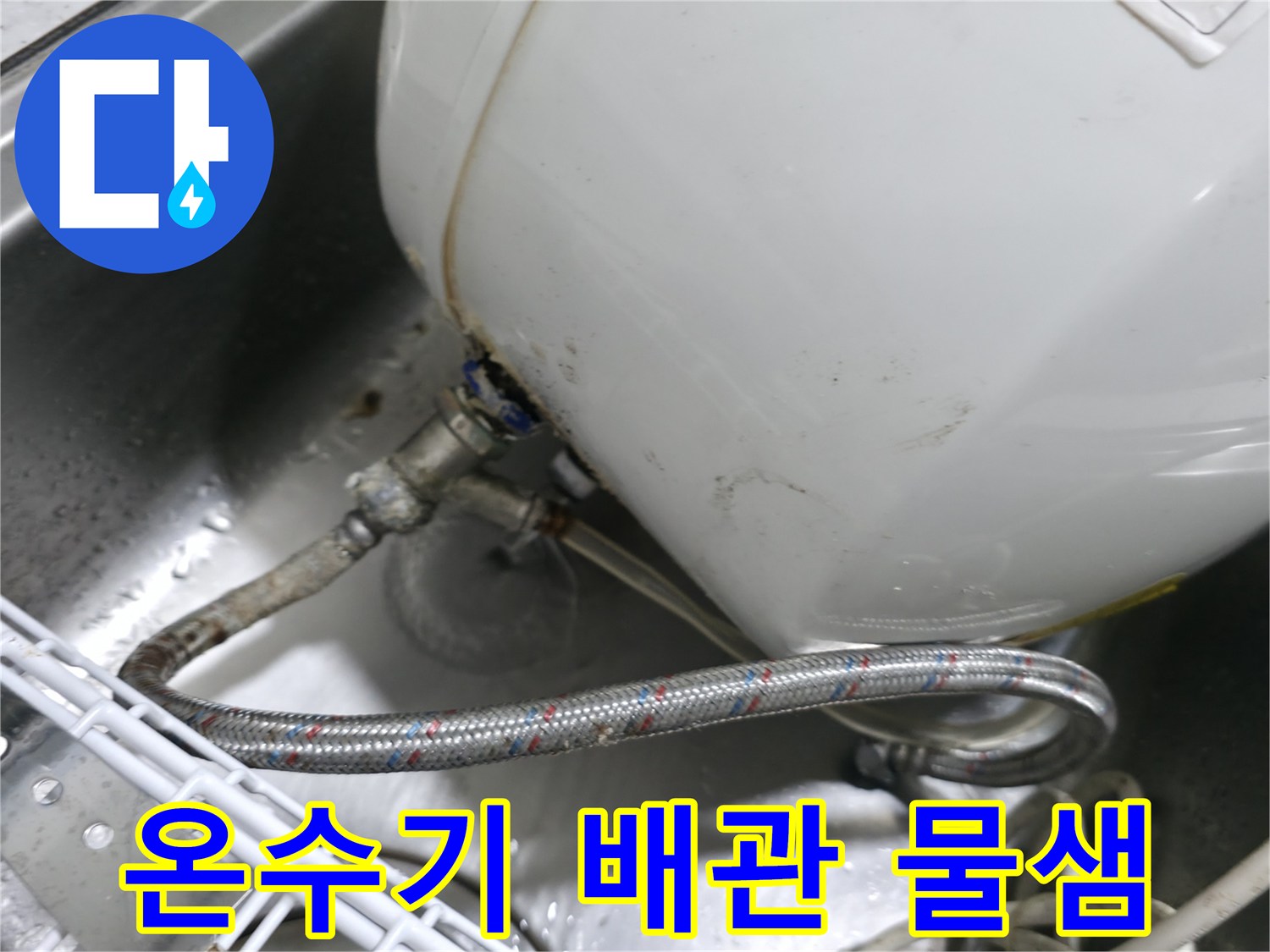 싱크대 하단에 설치된 전기 온수기와 노후된 급수 배관