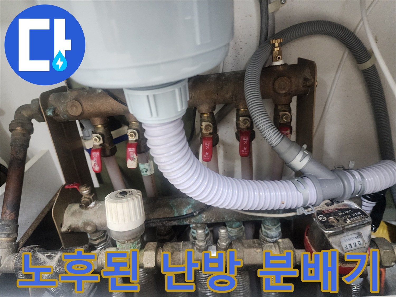 부식된 금속 배관과 연결 호스가 보이는 보일러 분배기 상세 사진