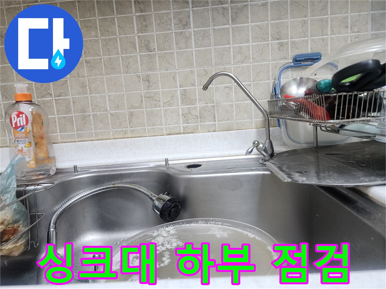주방 싱크대 수전 아래쪽의 밸브와 호스 연결 상태를 나타냅니다.