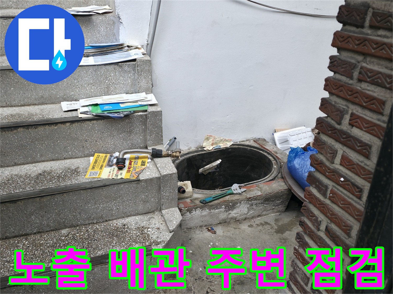 계단 옆 벽돌 외벽에 연결된 노출 배선 및 배관 상태