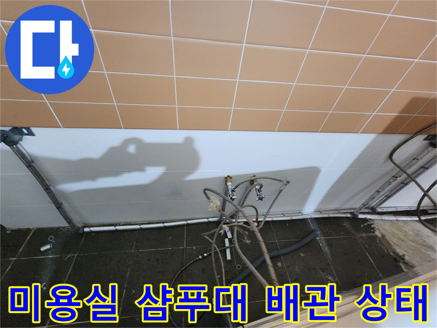미용실 샴류대 하단에 노출된 하수 배관과 연결 부위의 모습입니다.