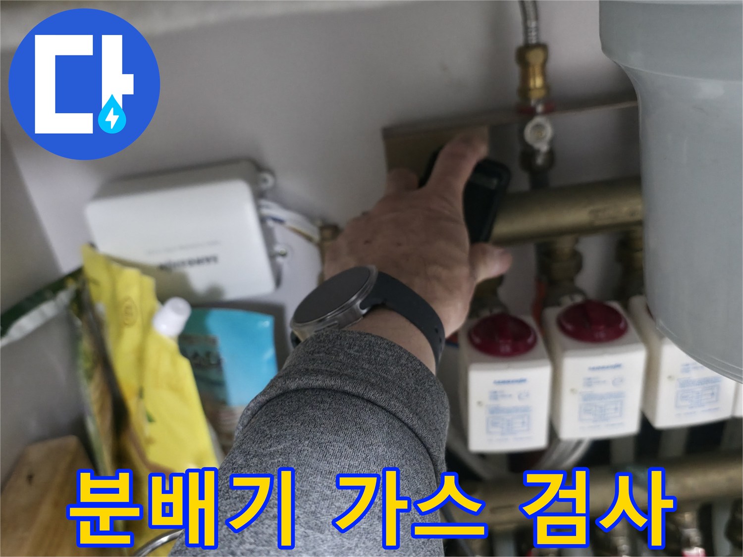 배관 밸브 부위의 누수 여부를 확인하기 위해 가스 탐지기를 대고 있는 모습입니다.