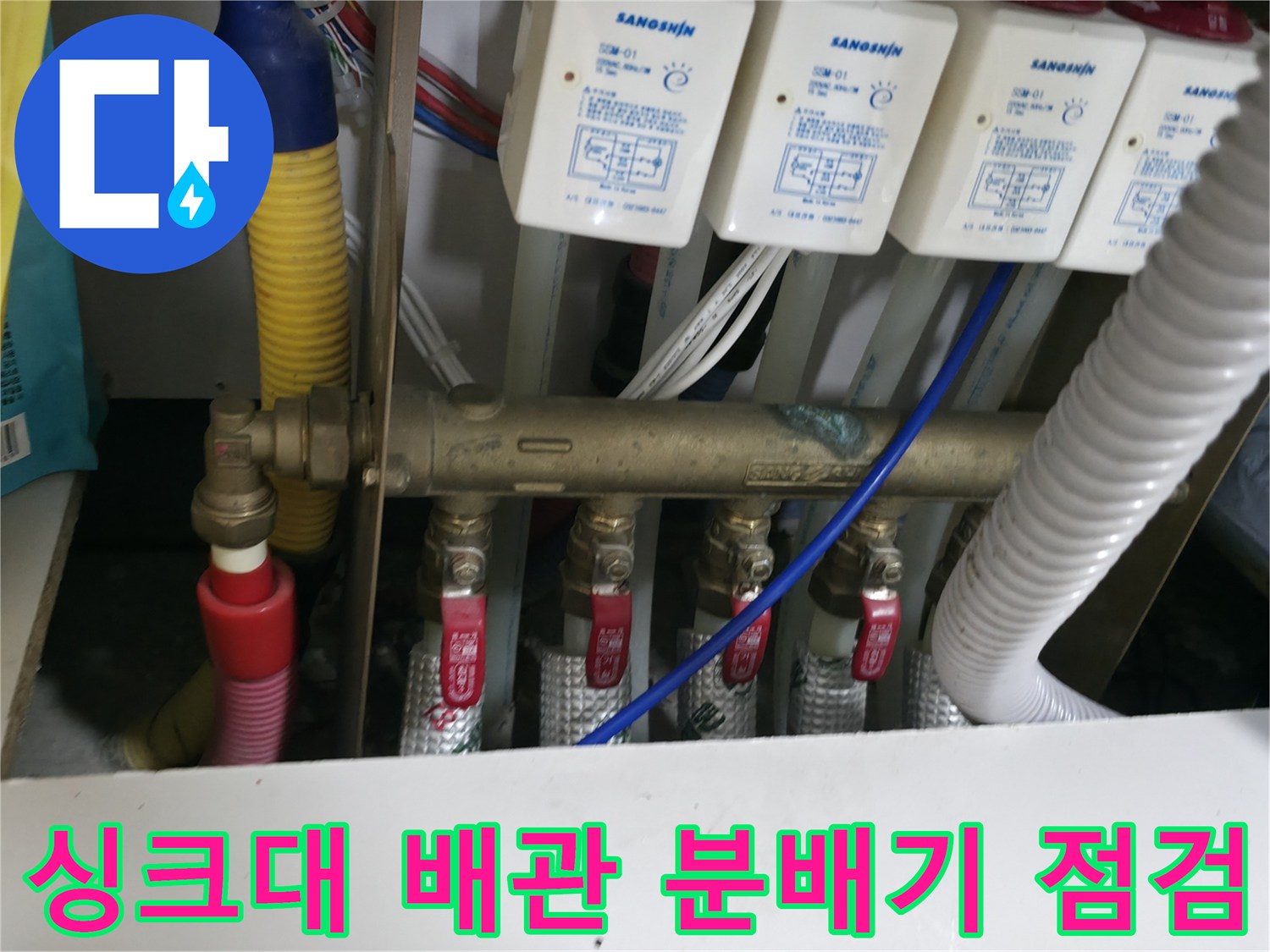 주방 싱크대 하부의 배관 분배기와 밸브 연결 부위 모습