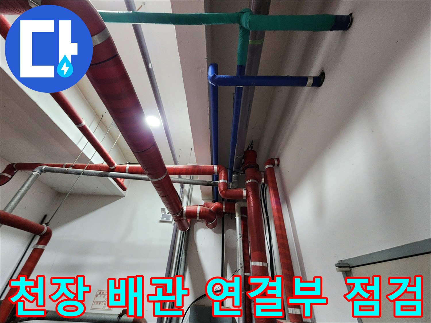 붉은색 보온재로 감싸진 천장 배관과 푸른색 배관의 교차 지점