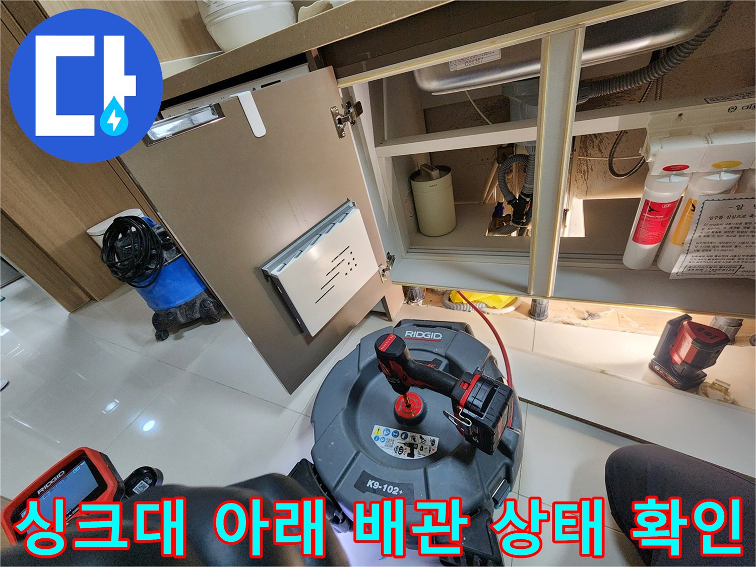 싱크대 밑 배수 호스와 연결 부품의 노후화 및 습기 상태를 보여주는 사진