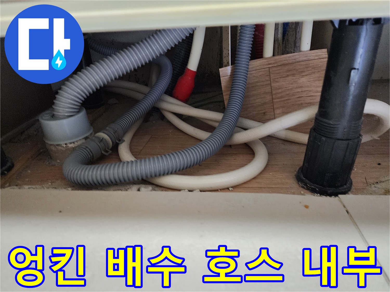 싱크대 하단에 배치된 회색 및 흰색 배수 호스들의 연결 구조