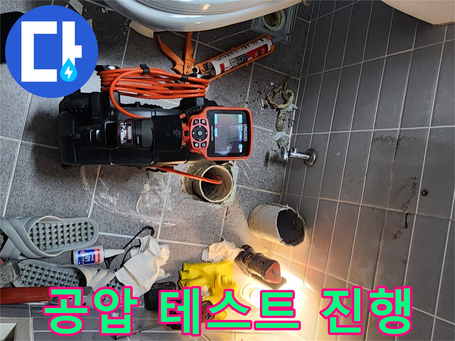 욕실 바닥에 설치된 배관 압력 측정 장비와 공구들