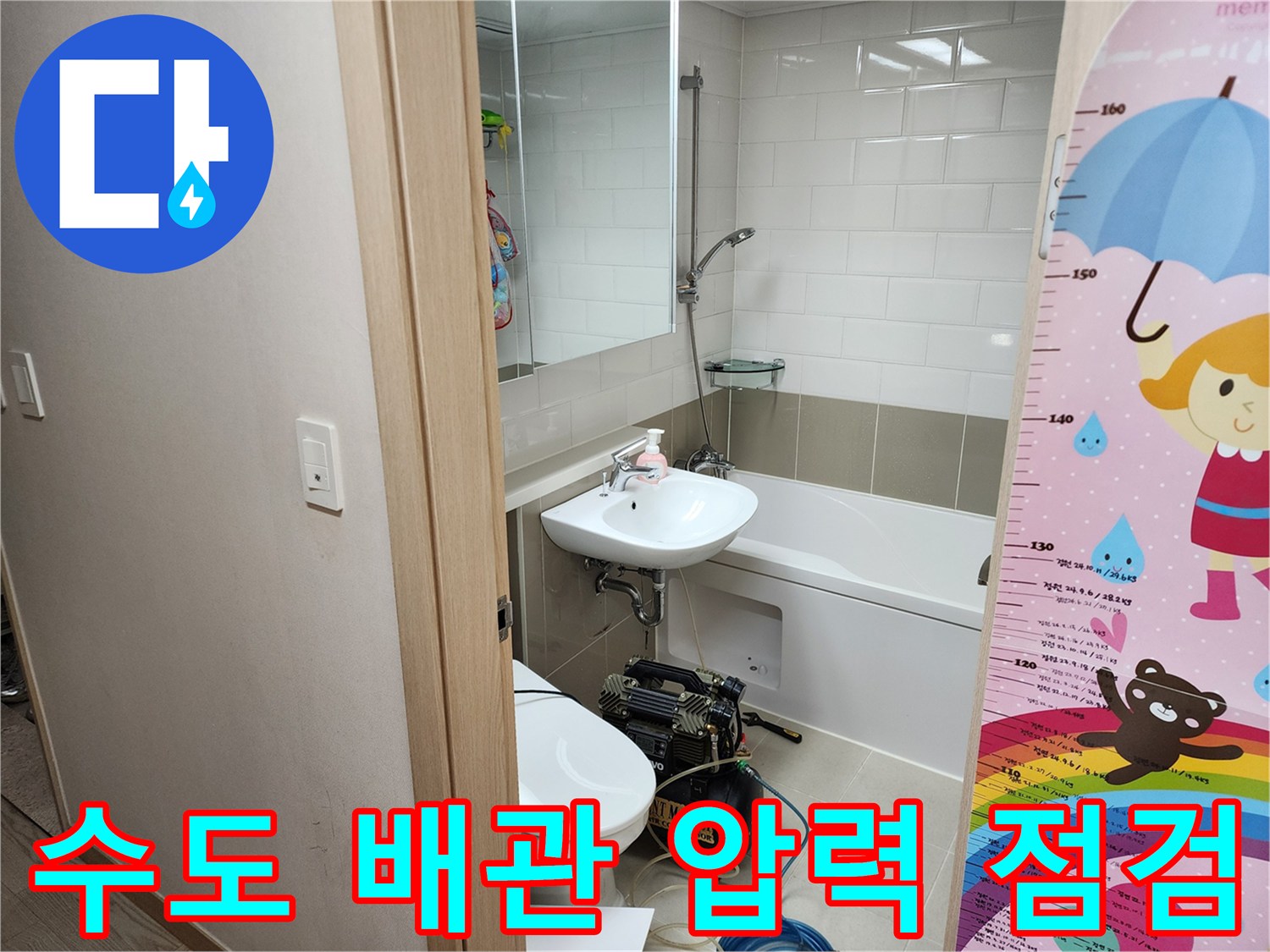 화장실 세면대 아래 놓인 디지털 압력계와 공압 테스트 장비