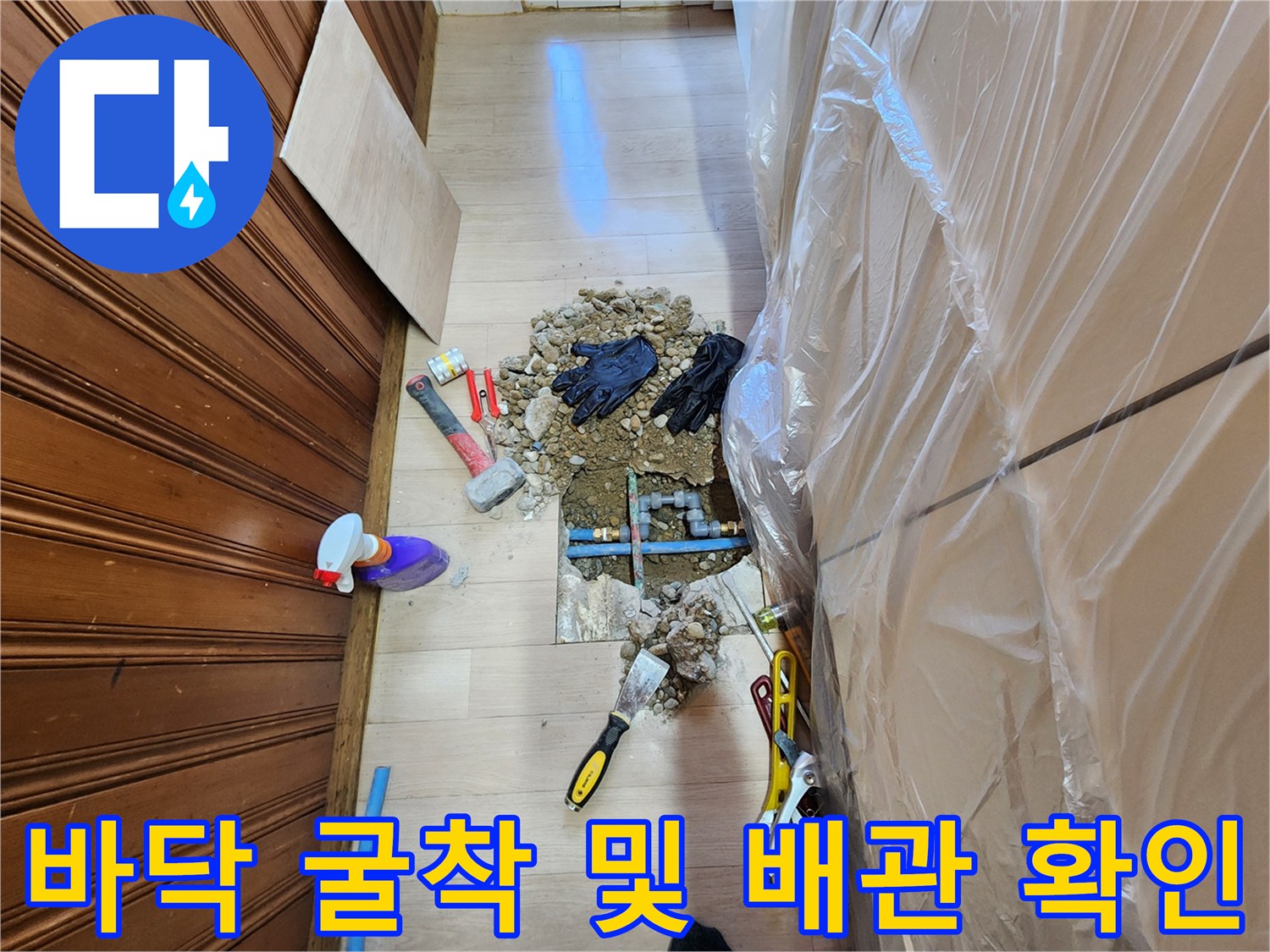 파헤쳐진 주방 바닥과 누수 지점 근처의 파란색 배관