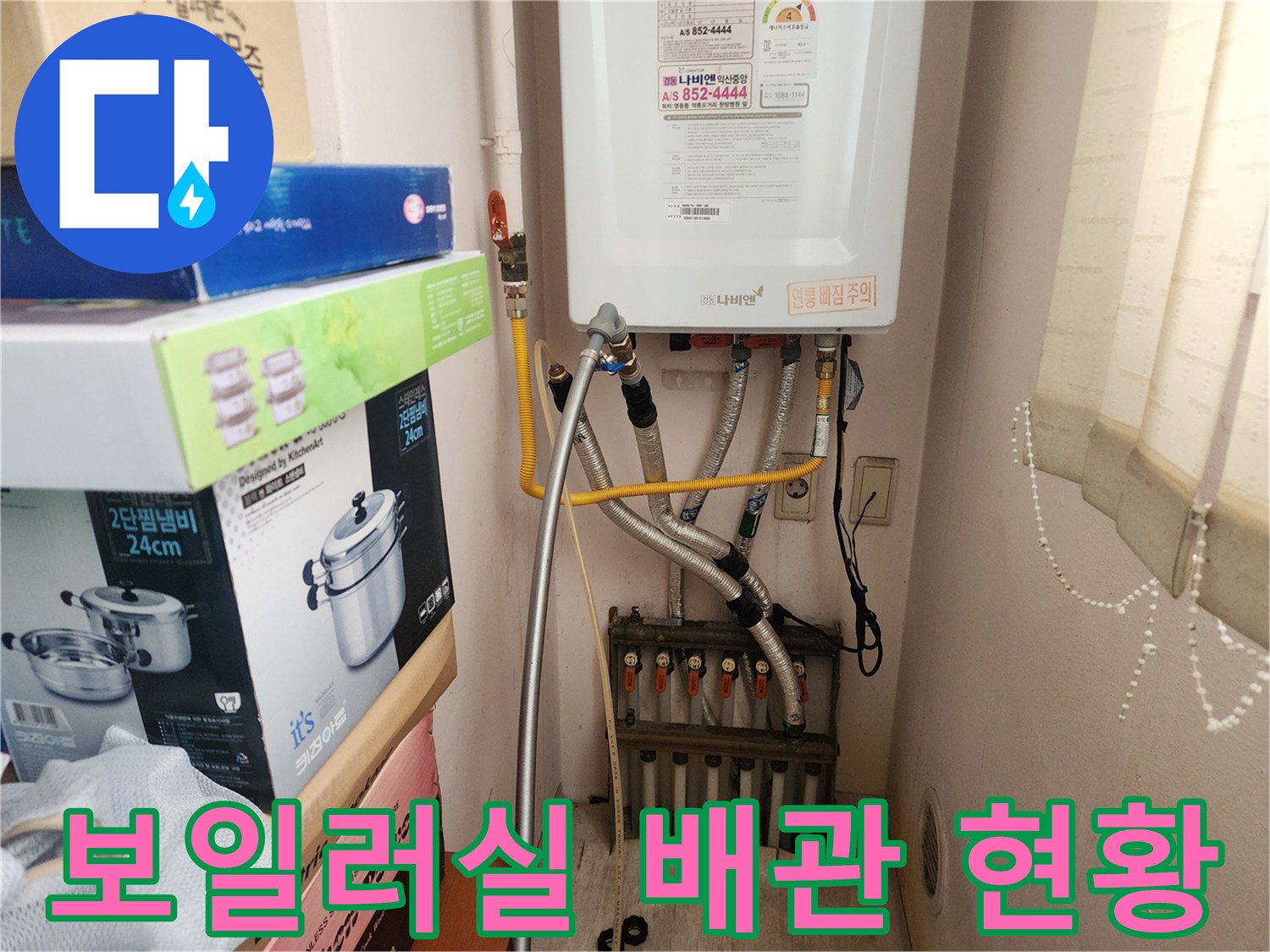 보일러 하단에 연결된 온수 및 냉수 배관의 상태를 보여주는 사진입니다.