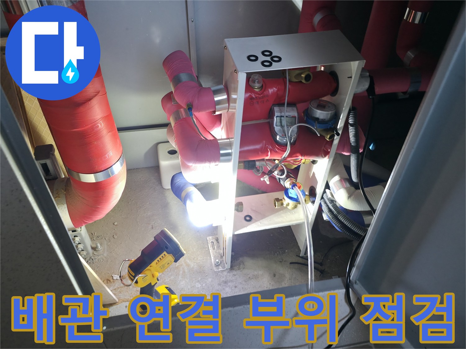 붉은색 배관의 연결 부위를 밝은 조명으로 세밀하게 확인하는 모습입니다.