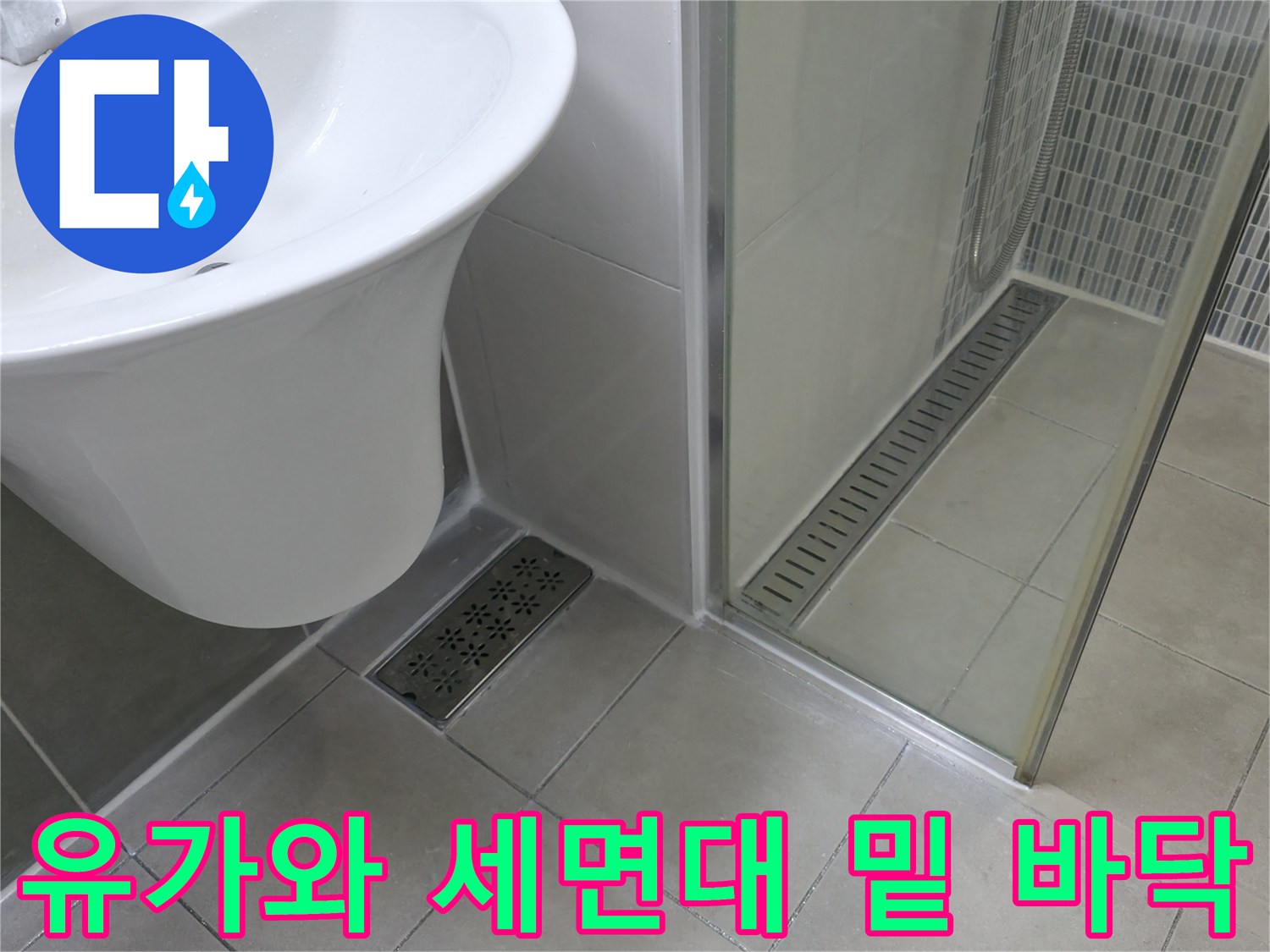 세면대 아래쪽 타일과 배수구가 보이는 현장 사진입니다.