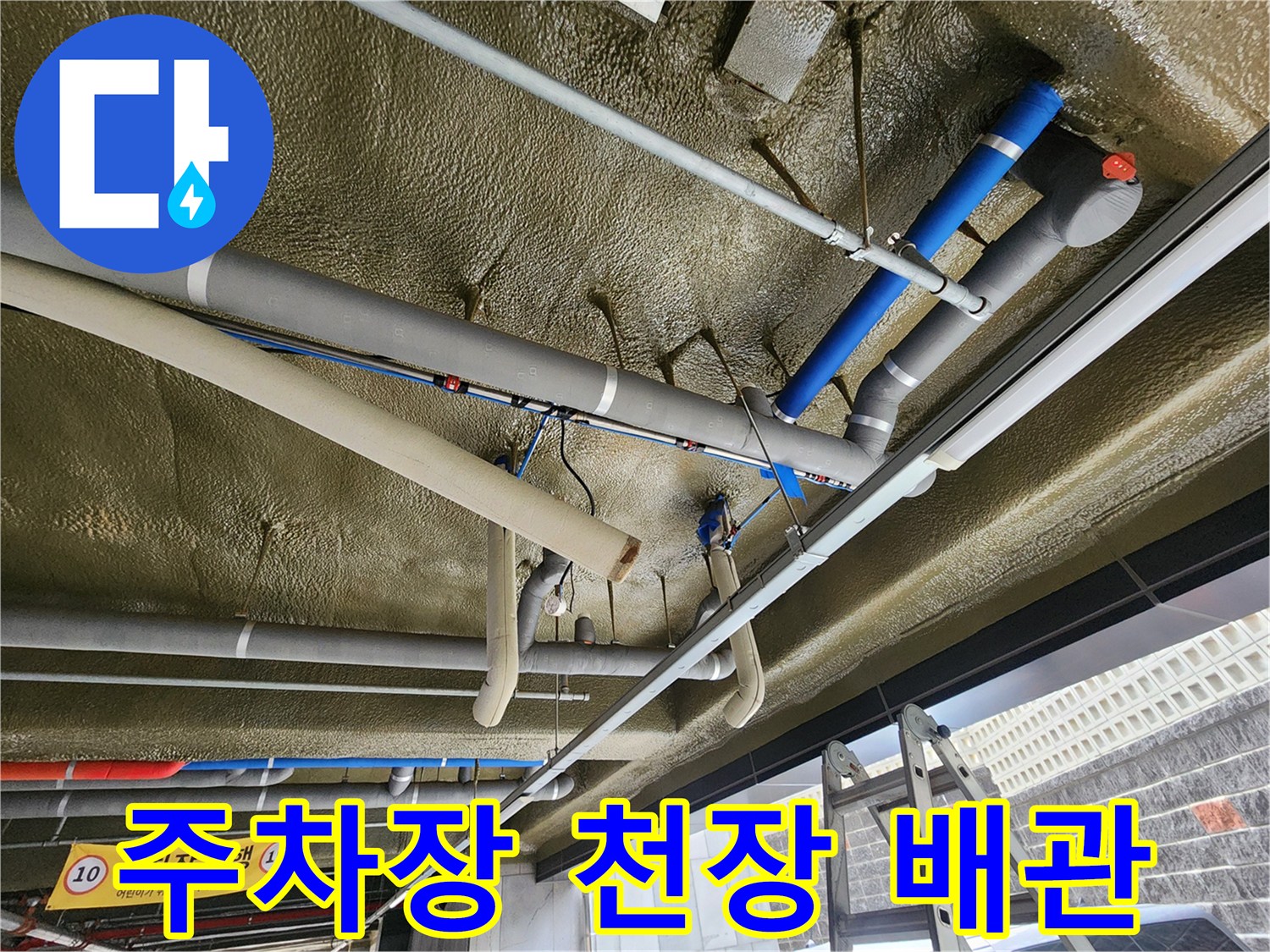 천장에 설치된 은색 배관과 파란색 보온재로 감싸진 배관의 근접 모습
