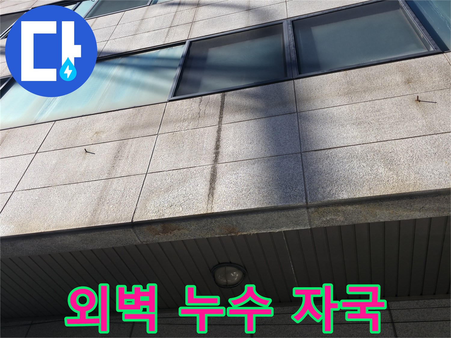건물 외벽의 수분 침투로 인한 변색된 석재 부위