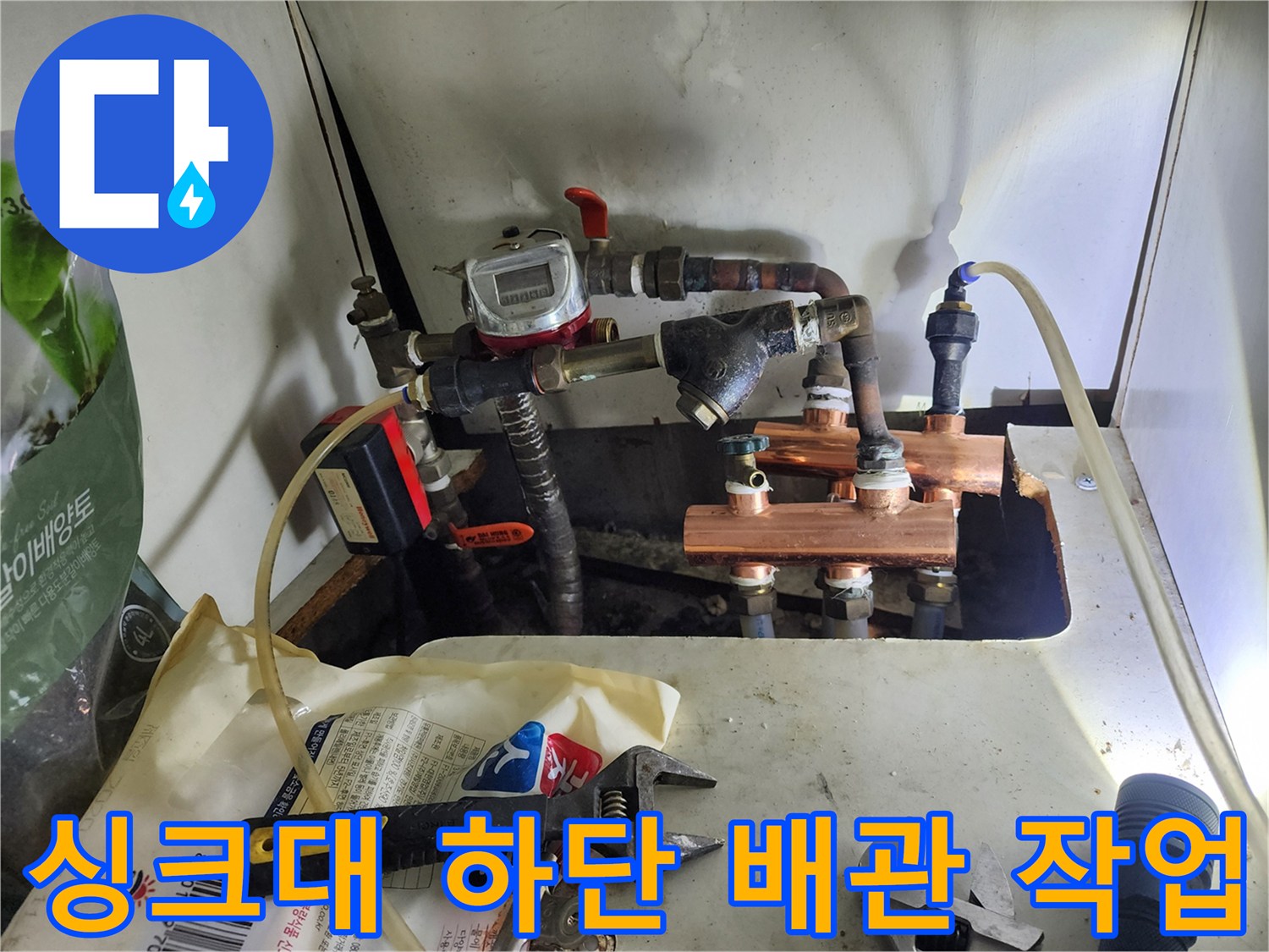 공구와 함께 진행된 싱크대 밑 배관 교체 및 누수 보수 작업 현장입니다.