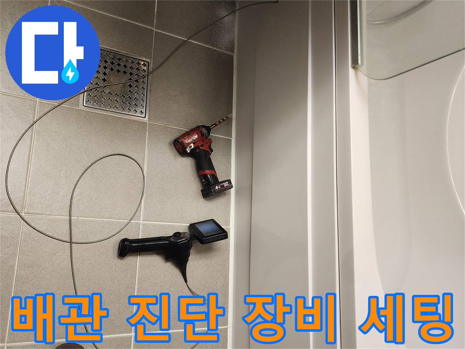 욕실 바닥 타일 위-작업을 위해 준비된 전동드릴과 내시경