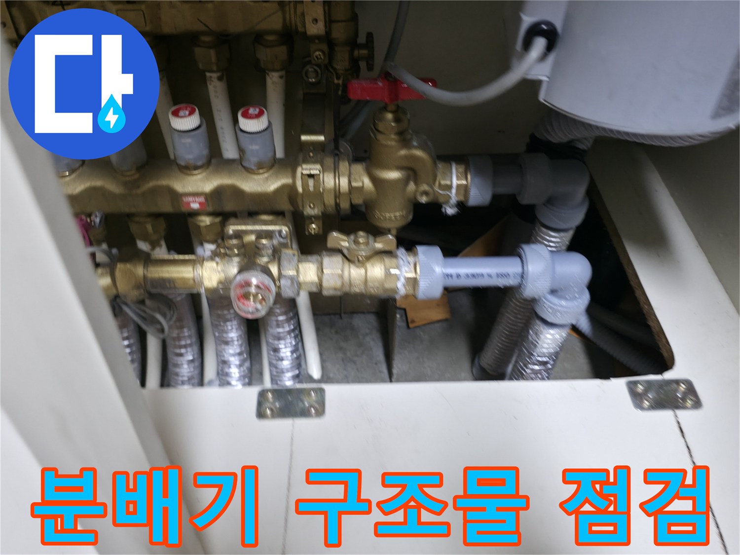신발장 내부의 금색 밸브와 은색 이중배관 연결 상태