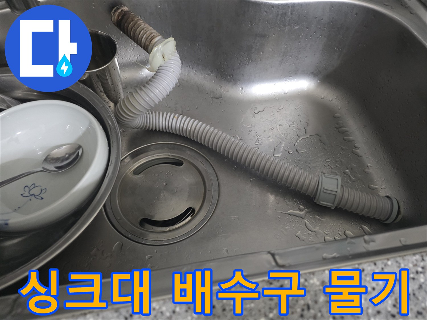 물기가 맺힌 싱크대 내부와 배수 호스 연결 부위 사진
